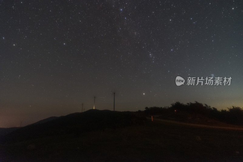 山顶上的星空夜景与风力发电机