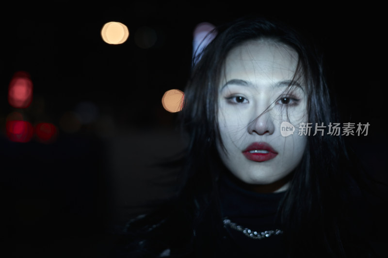 夜晚站立在橱窗外的亚洲少女