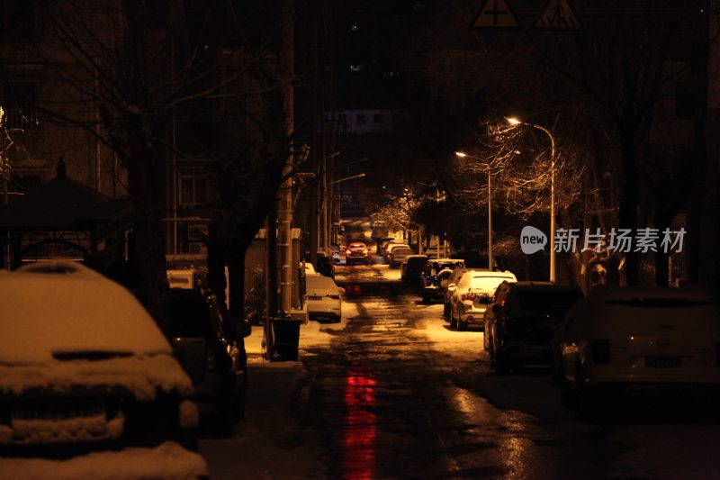 夜晚积雪街道及停放车辆