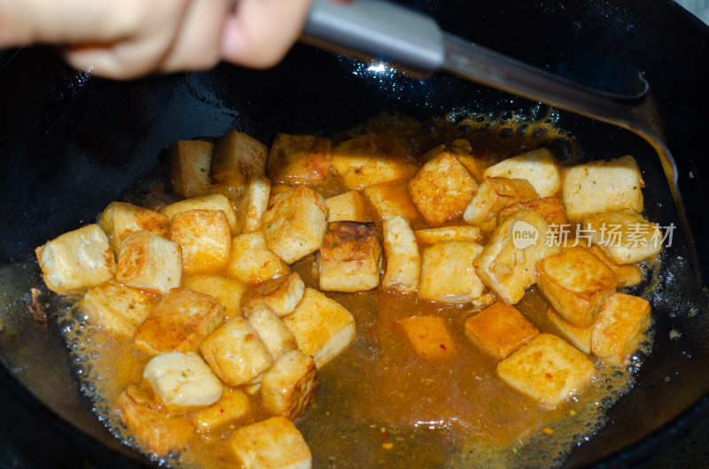 铁铲搅拌着锅里的麻婆豆腐