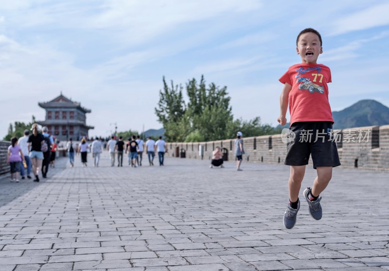 小男孩在古城墙上跳跃