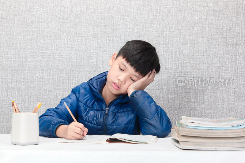 小男孩伏案写作业场景