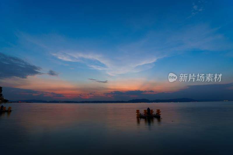 日落时的湖景和多云的天空