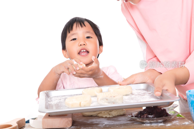 中国小女孩把做好的月饼放在烤盘里