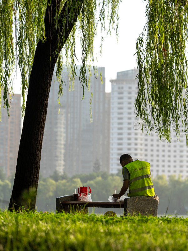 清晨公园里 吃早餐的建筑工人背影