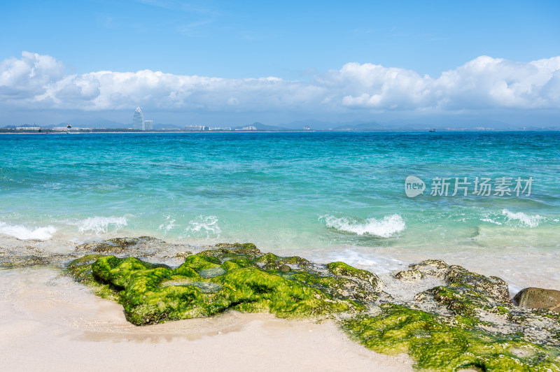 阳光下的海南三亚海岸线上礁石沙滩海浪浪花