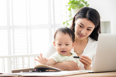 年轻妈妈带着宝宝看电脑