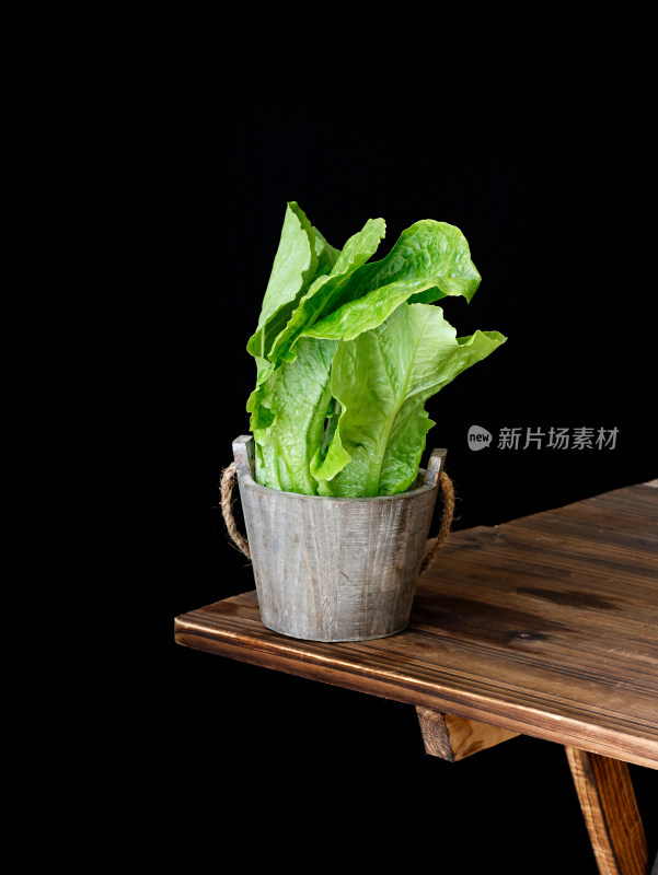 木桌子上，菜篮子里装满着绿色蔬菜