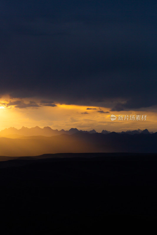 山峰日落时天空映衬的剪影景观