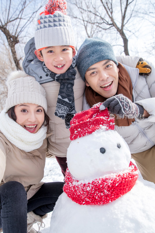 一家三口在雪地里堆雪人