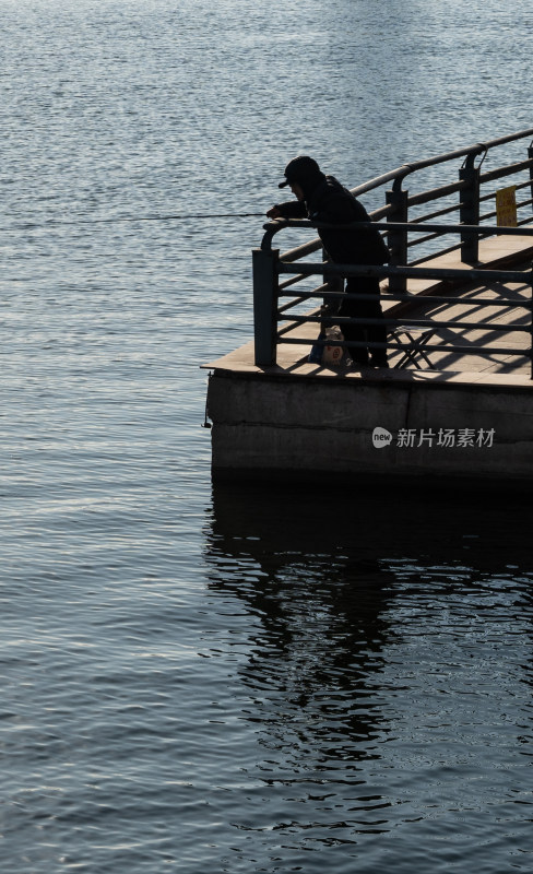 水边平台上钓鱼的人