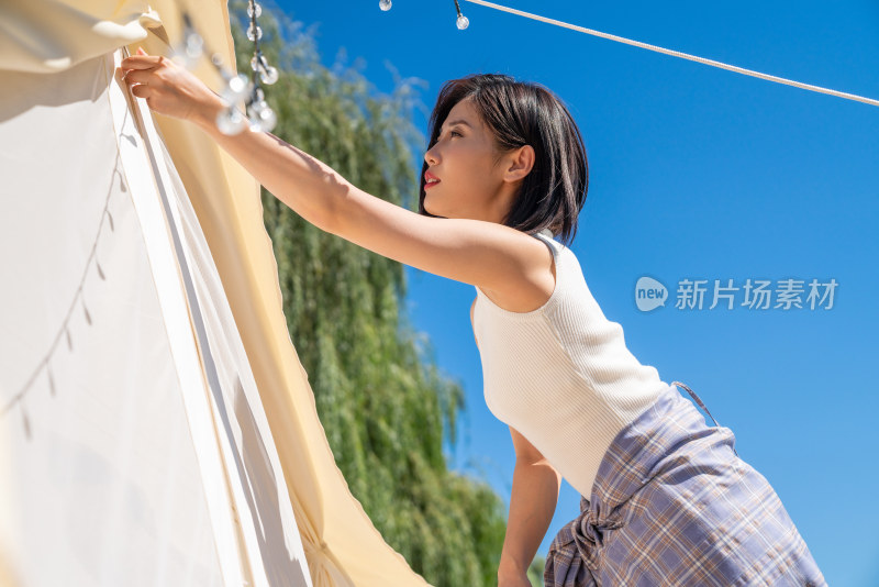 女孩在露营地搭建帐篷