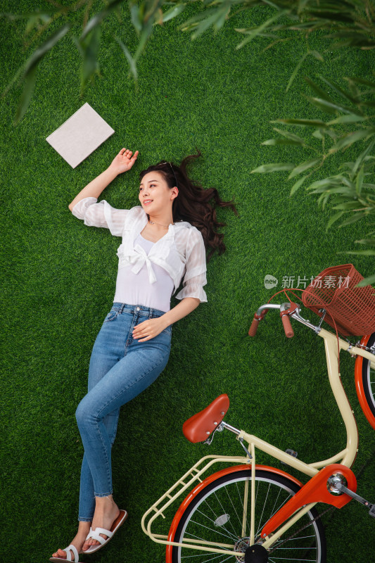躺在草地上享受大自然的青年女人