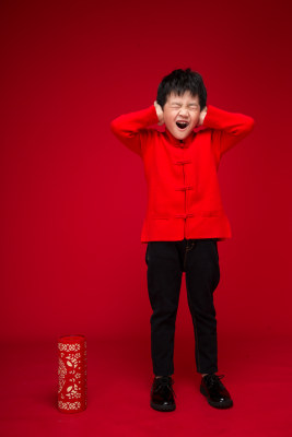 红色背景下的中国小男孩和鞭炮