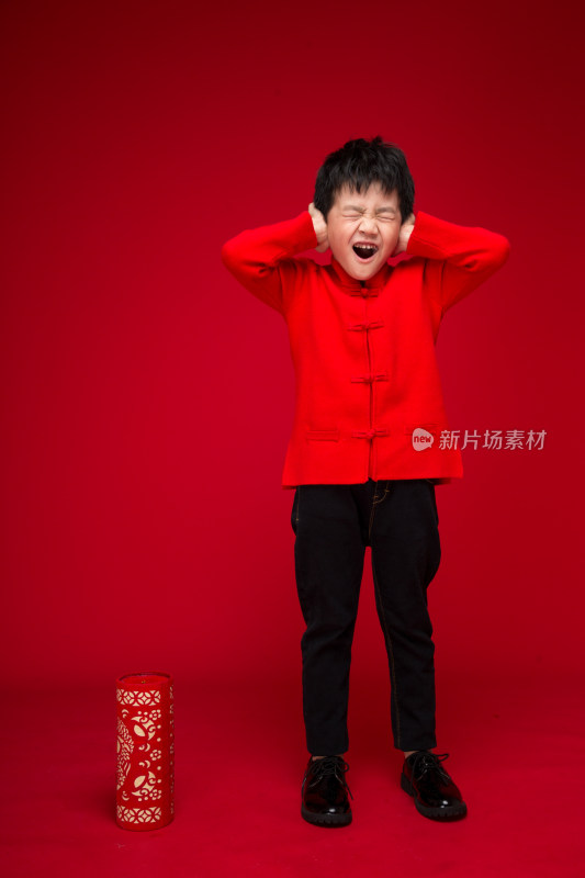 红色背景下的中国小男孩和鞭炮