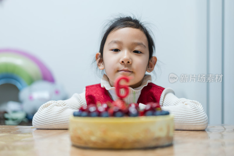 中国女孩凝望着的生日蛋糕