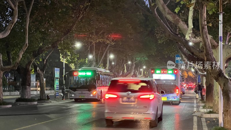 夜晚道路上的汽车与公交车行驶场景