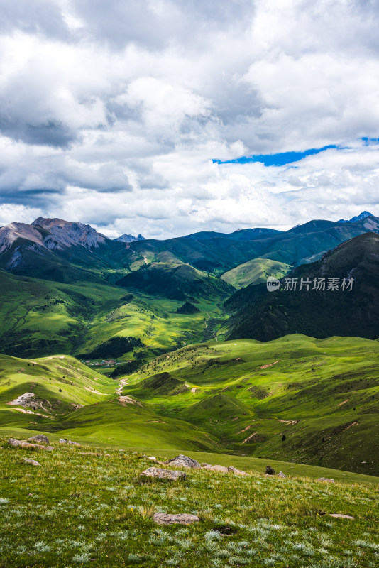 蓝天白云下广袤草原与连绵山峦自然风景