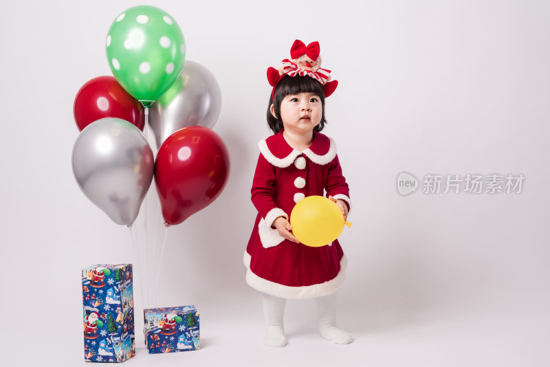 白色背景前穿圣诞礼服的中国女童