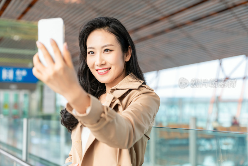 年轻女子在机场使用手机