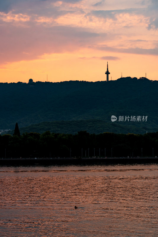 湖畔日落山丘与电视塔景观