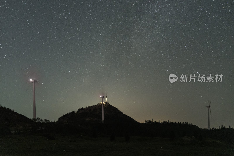 山顶上的星空夜景与风力发电机