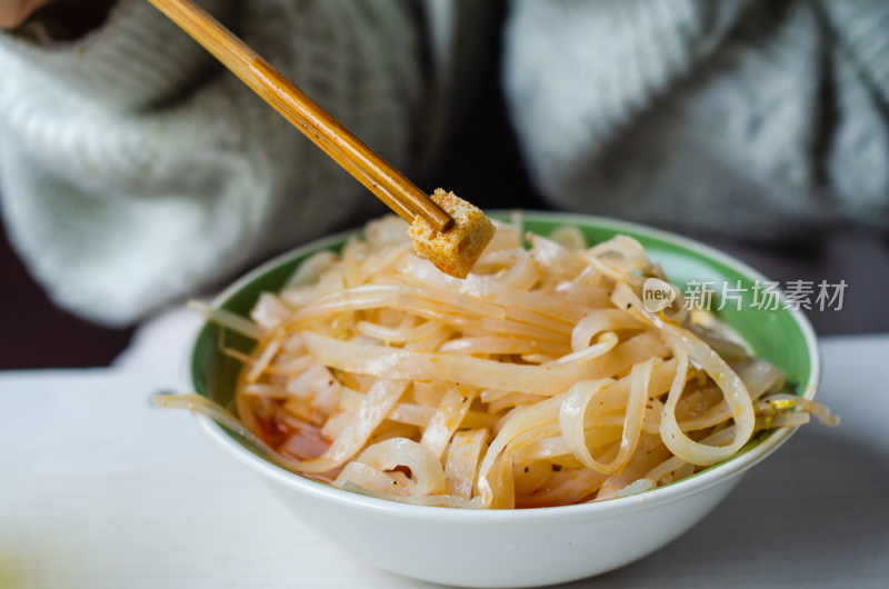 一碗陕西特色美食凉皮中夹起一块面筋