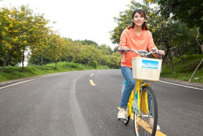 一个年轻女大学生在校园里骑车