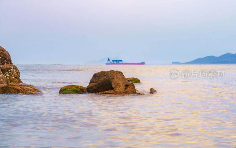 山东青岛太平角公园，夕阳中海上的巨石轮船