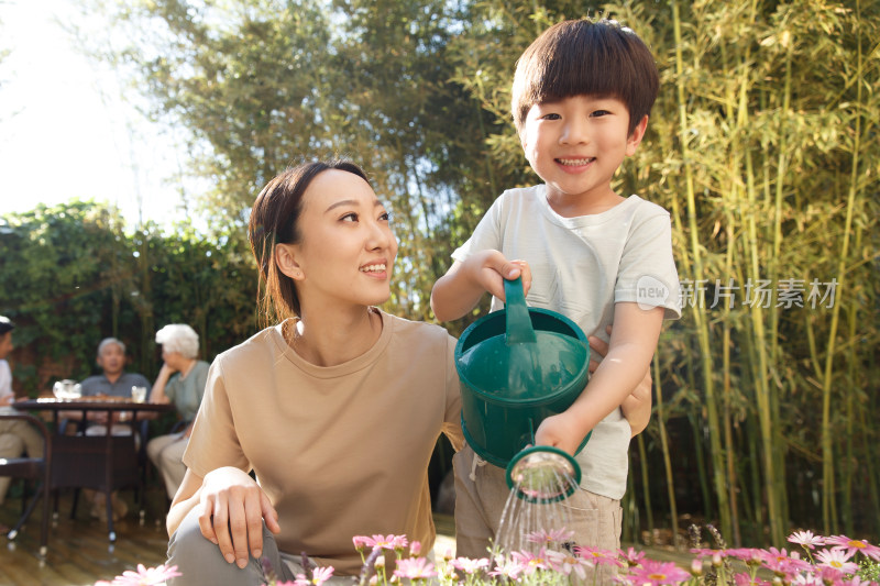 母亲和儿子在花园里浇花