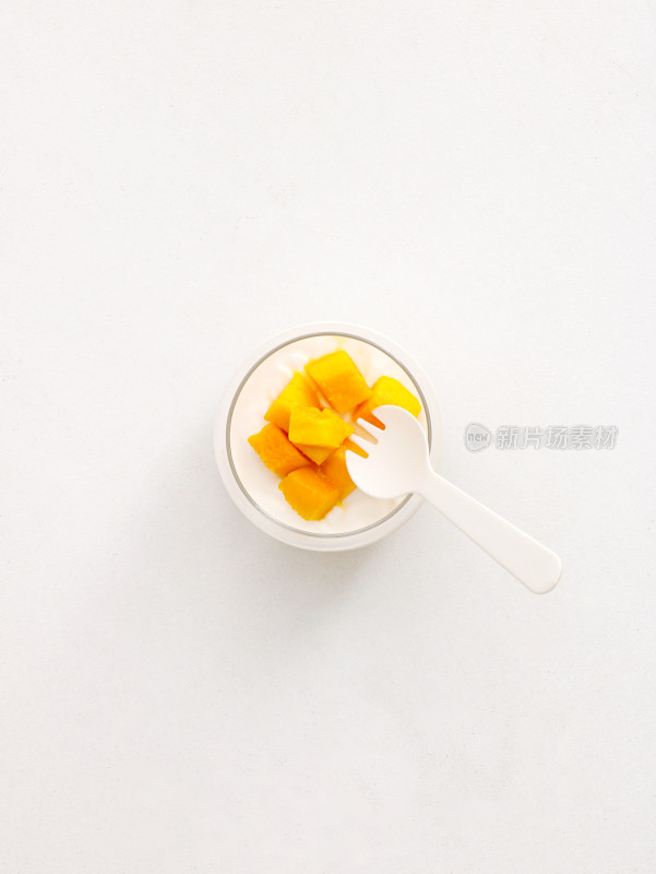 白色桌面上的一杯芒果布丁饮品