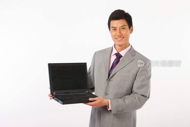 商务男士抱着笔记本电脑