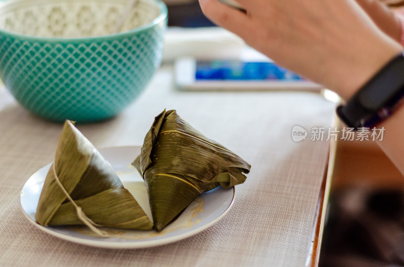 准备吃放在盘中的两个粽子