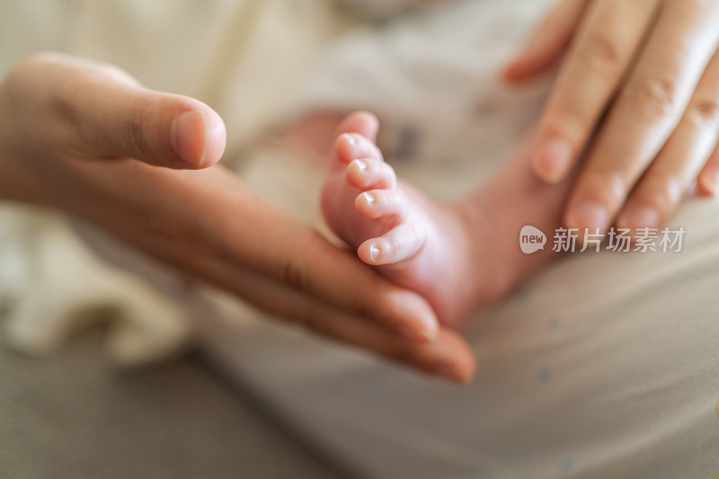 妈妈的大手温柔抚摸宝宝的小脚