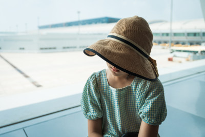 拖行李箱在机场等待登机的中国女孩