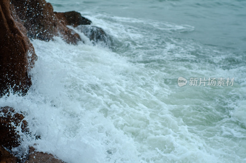 海边飞溅的浪花拍打着礁石