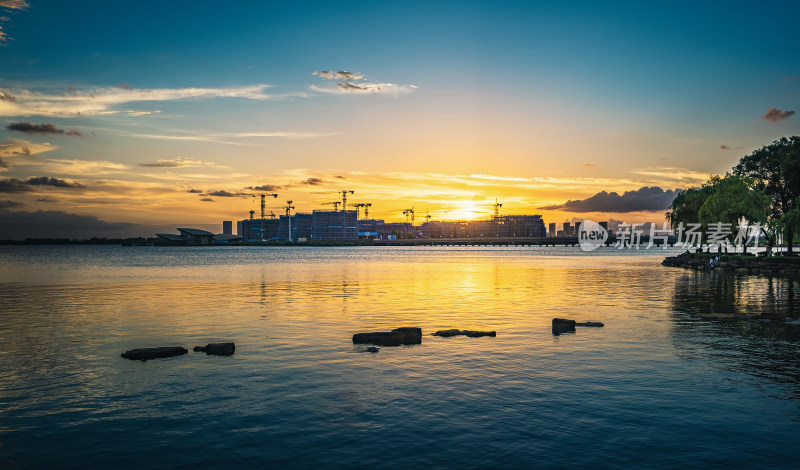 湖畔夕阳下的城市建设景观