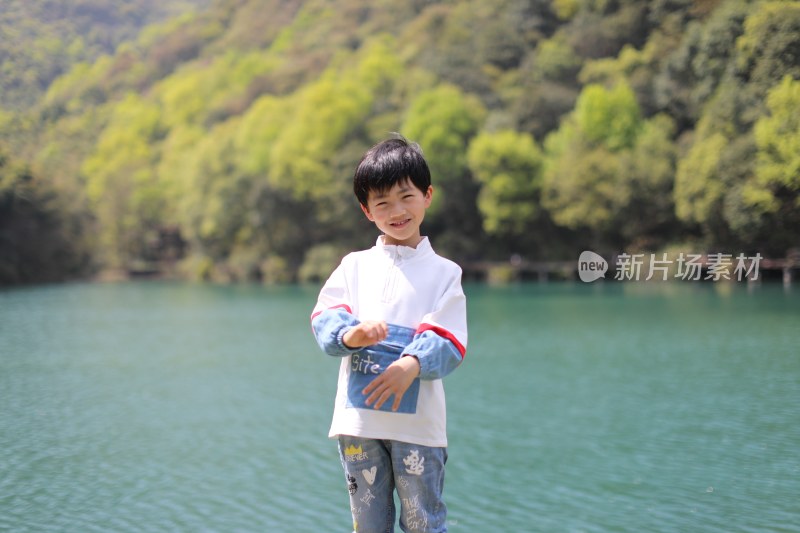 站立在湖边的中国小男孩