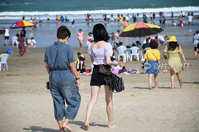 两人在热闹海滩漫步