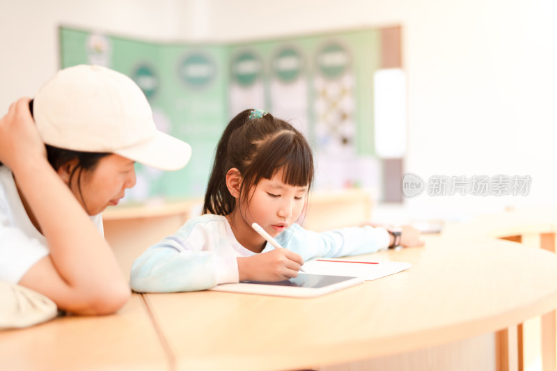 妈妈认真辅导女儿学习在图书馆