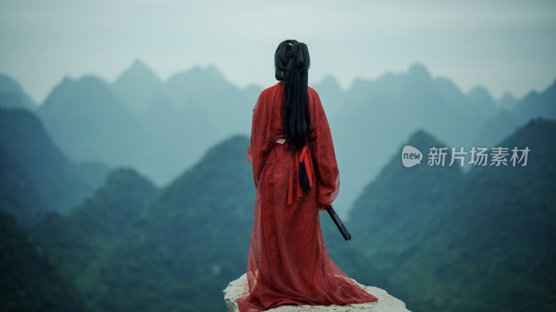 红衣古装女子眺望山峦