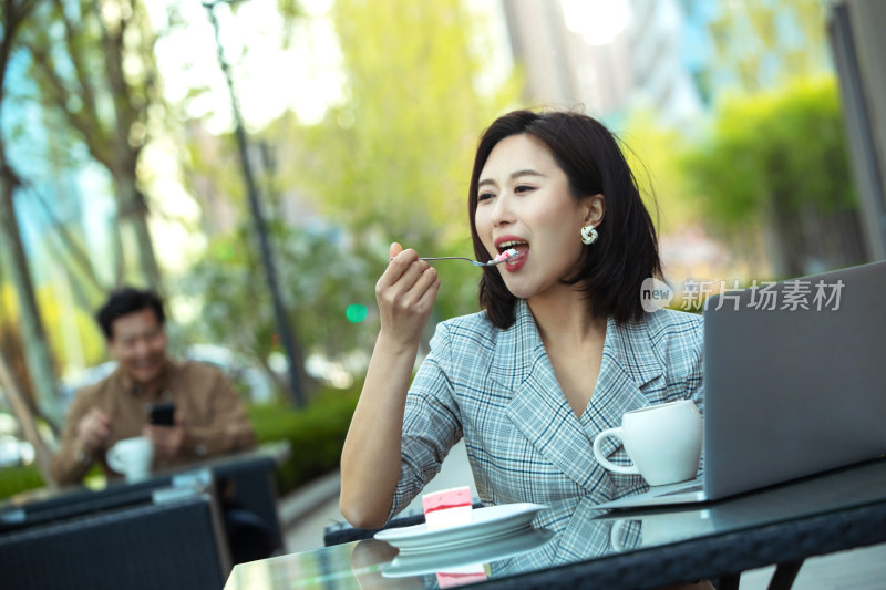 年轻女性坐在露天咖啡厅里