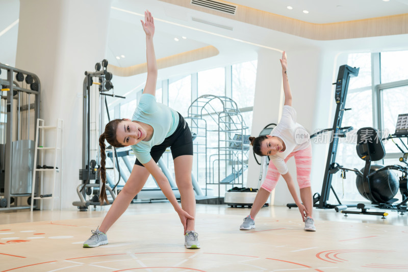 两个年轻女子在健身房健身
