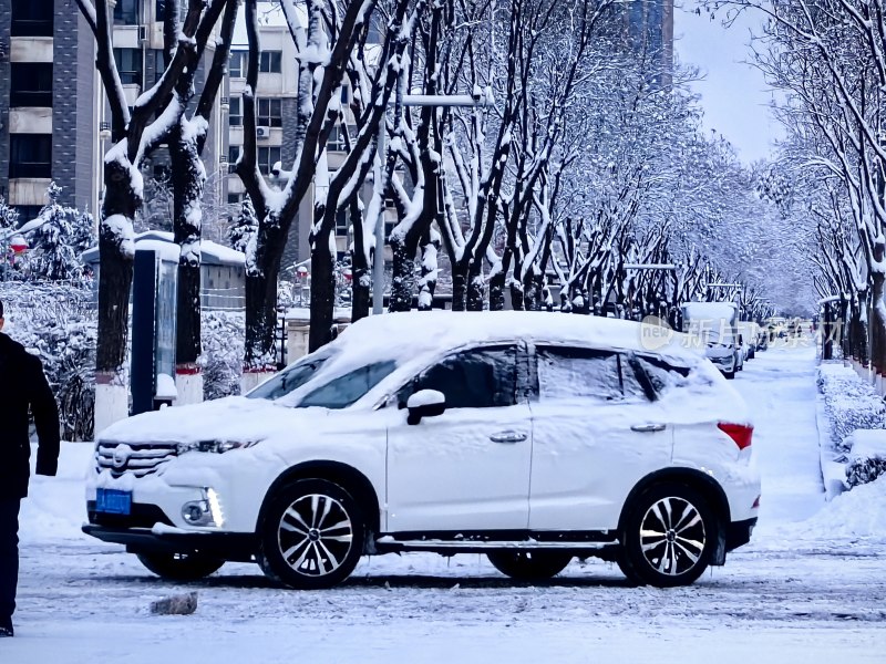 积雪覆盖的街道上停着一辆白色汽车