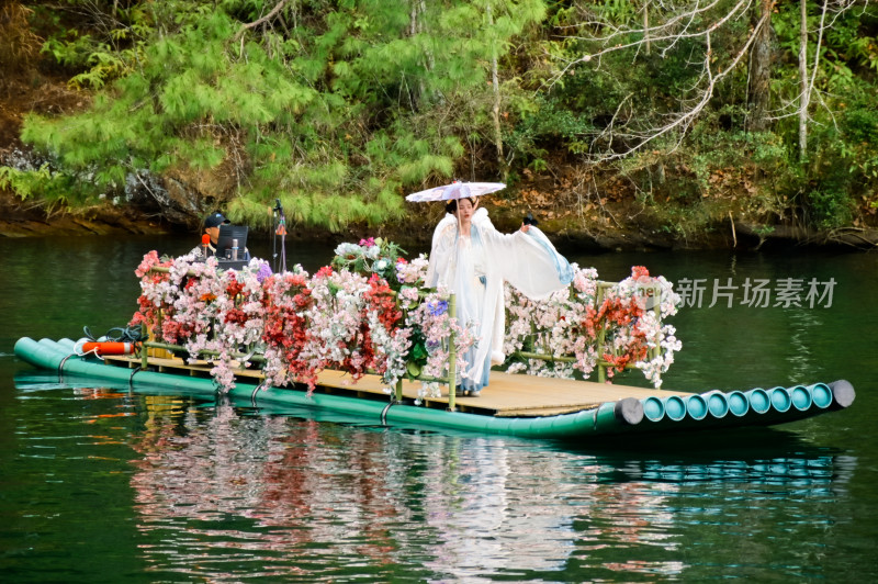 古装女子撑伞站在水上花船中