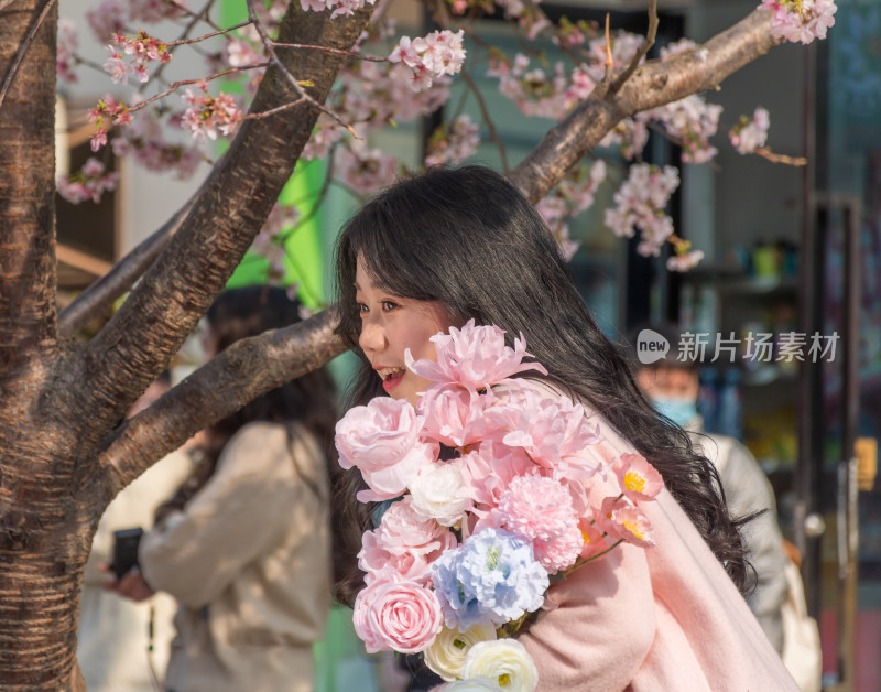 女子于樱花树下微笑留影