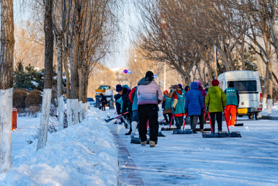 户外道路上的集体铲雪活动场景