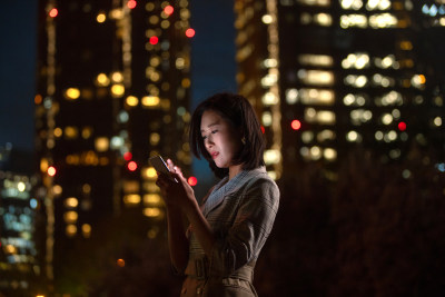 晚上在户外看手机的商务女白领