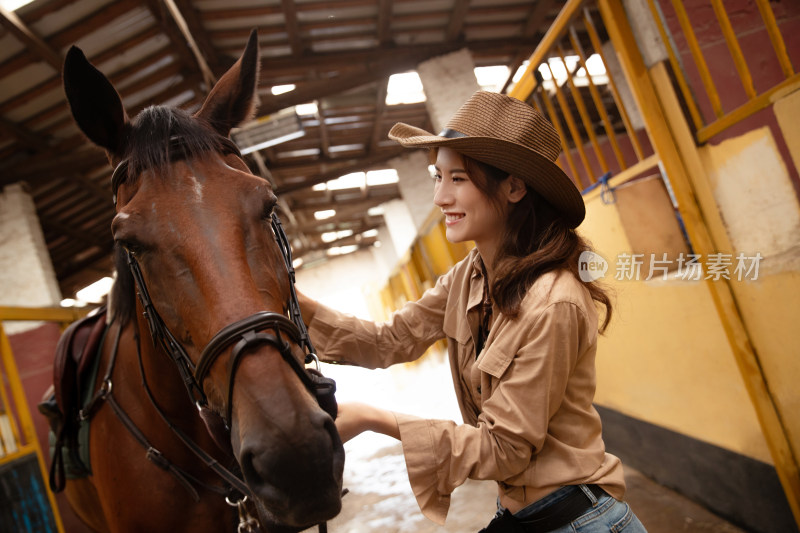 马厩里的快乐的青年女人和马