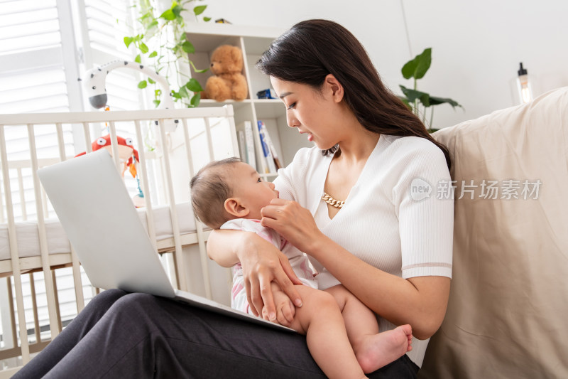 年轻妈妈带着宝宝看电脑